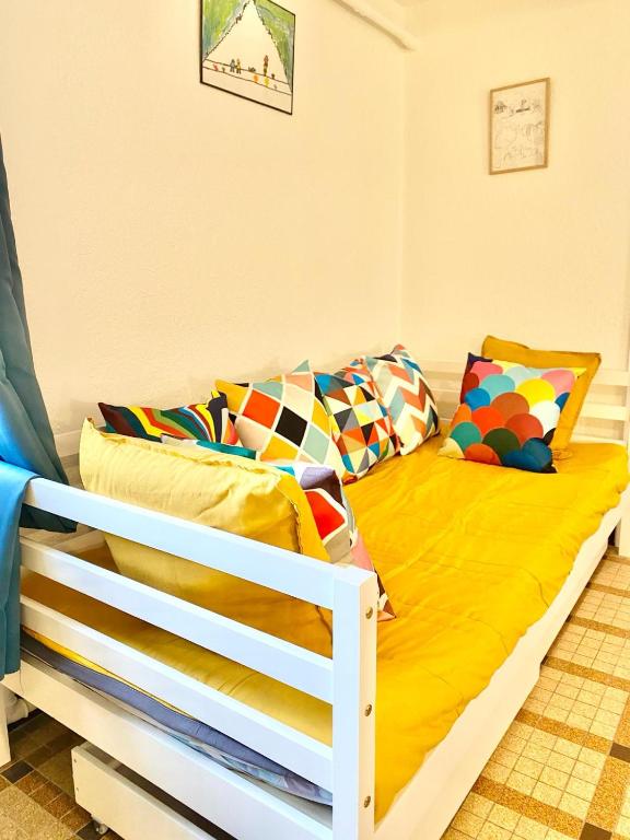 - un lit avec des draps et des oreillers jaunes dans l'établissement La Caravelle 2 pièces sur jardin, à Montrichard