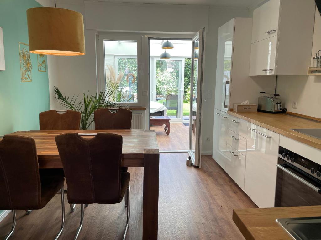 a kitchen and dining room with a wooden table and chairs at Tohuus1875 in Warendorf