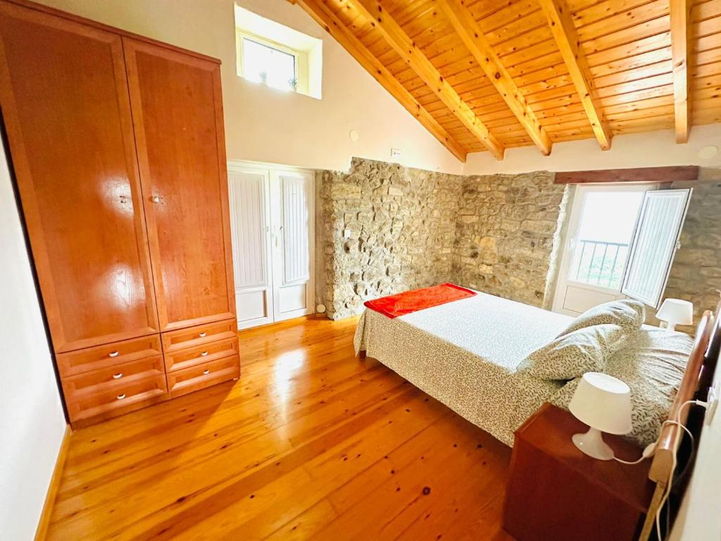 a bedroom with a bed and a wooden floor at Casa Nieves Alojamiento Rural in Ampuero
