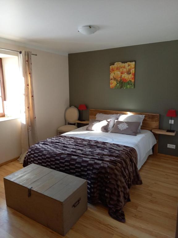 une chambre avec un grand lit dans une pièce avec un box dans l'établissement Sous Le Tilleul, à Sénaillac-Latronquière