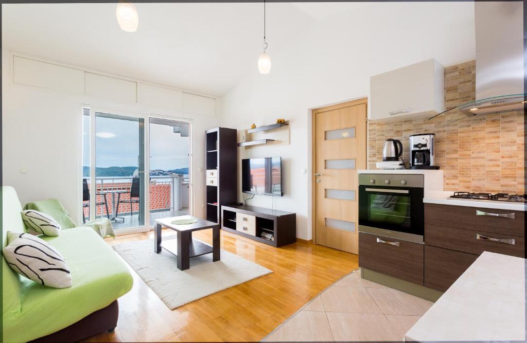 a kitchen and living room with a couch and a stove at Apartment Mia - Spacious apartment on 85 m2 with beautiful sea view in Trogir