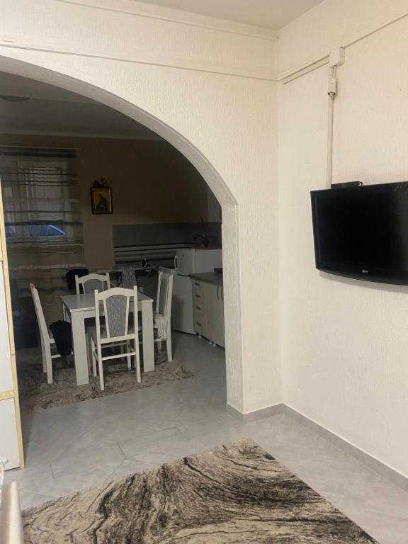 sala de estar con mesa con sillas y TV de pantalla plana en Guest House Bajceta, en Herceg-Novi