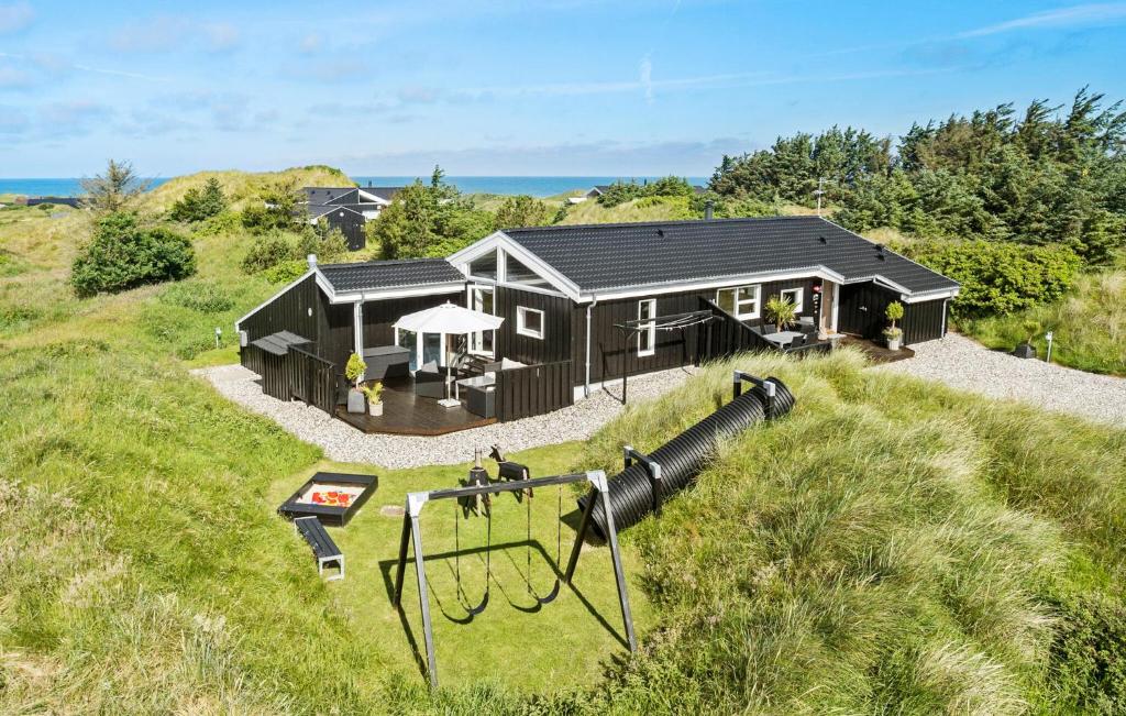 a house with a playground in front of it at 4 Bedroom Nice Home In Saltum in Saltum