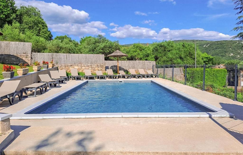 a swimming pool in a backyard with chairs and tables at Beautiful Apartment In Vallon Pont Darc in Vallon-Pont-dʼArc