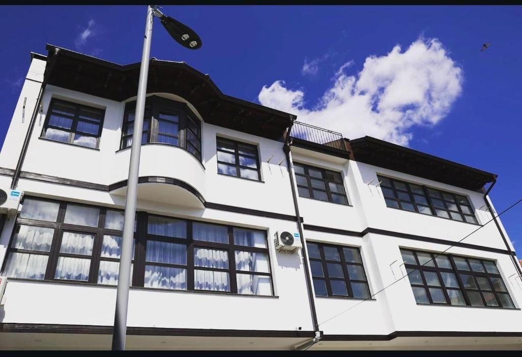 プリズレンにあるIn Time Apartmentの窓旗のある白い建物