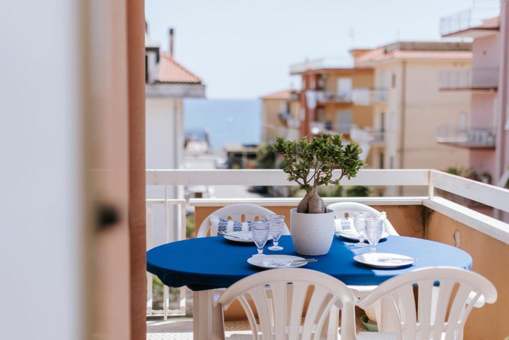 a blue table with chairs and a potted plant on a balcony at Casa Ferrari Vista Mare in Formia