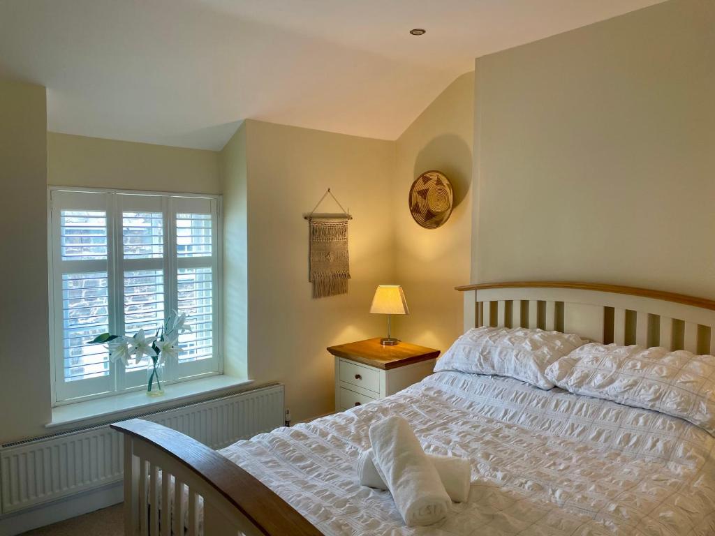 ein Schlafzimmer mit einem weißen Bett und einem Fenster in der Unterkunft Conwy Castle cottage in Conwy
