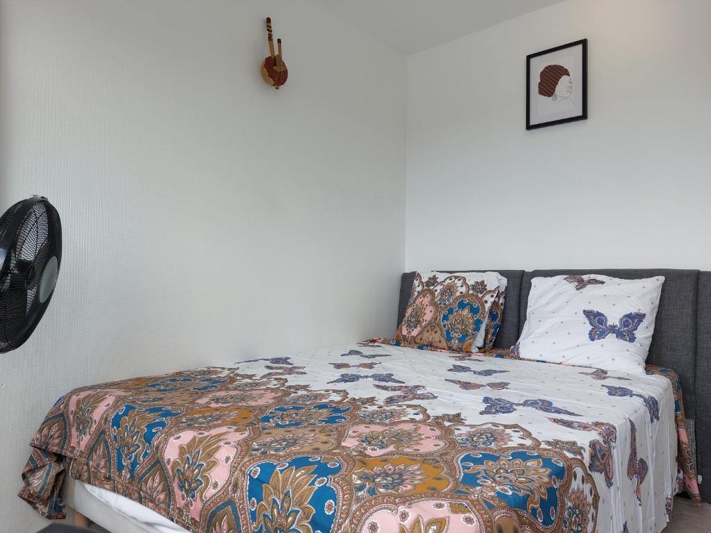 a bedroom with a bed with a comforter and pillows at Appartement au Duleing House in Orléans