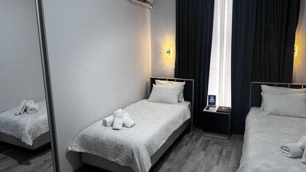a hotel room with two beds with towels on them at Marmar Family Restaurant and Hotel in Nukus