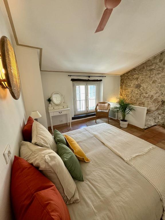 une chambre avec un grand lit avec des oreillers dessus dans l'établissement Charming house in Valbonne village, à Valbonne