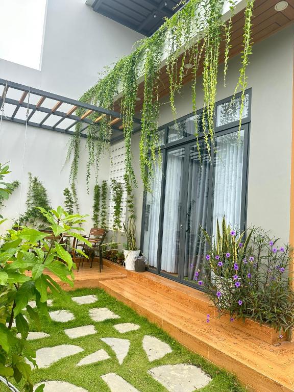 a patio with plants on the side of a building at Á Châu homestay in Ấp Thanh Sơn (1)