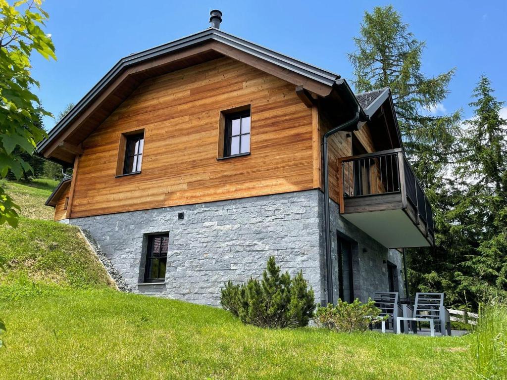 a house on top of a hill with a balcony at Tomtegl-Bergchalet-No-6-mit-Privatsauna-Infinitypool-Kamin-Fitnessraum-1500m-Seehoehe in Hochrindl