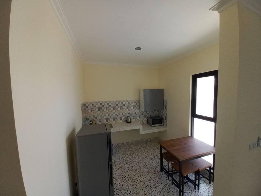una cucina con un frigorifero e un tavolo di Guesthouse Jogja Selatan 1 Yogya South-Bantul Casa del Oceano a Gandok