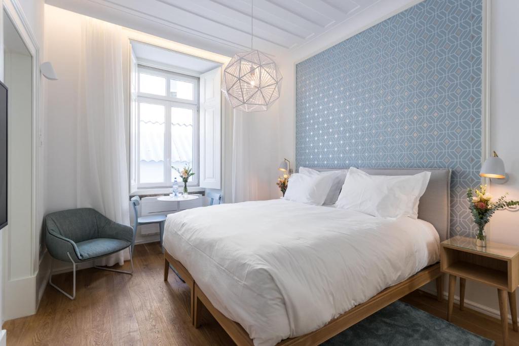 una camera da letto con un letto grande e una parete blu di Boutique Chiado Suites a Lisbona