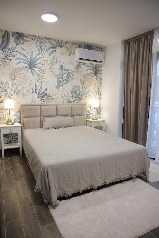 a bedroom with a large bed with blue and white wallpaper at Adagio Apartmani in Vrnjačka Banja