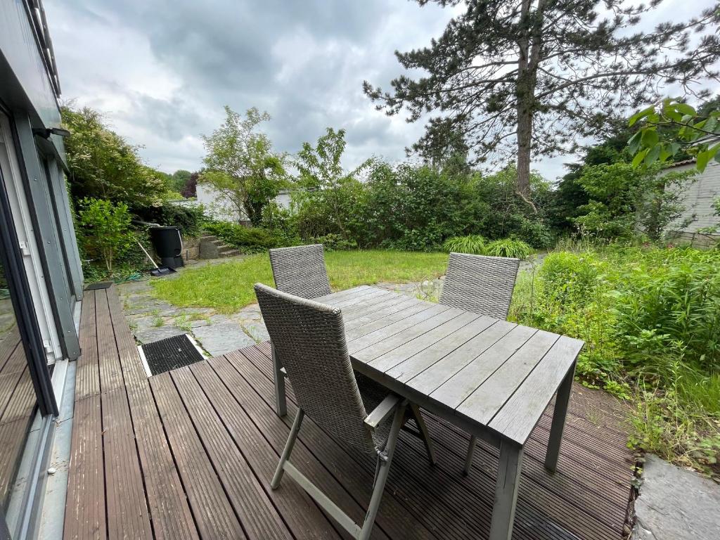 a wooden table and chairs on a deck at Ferienwohnung FördeGlück an der Kieler Förde in Mönkeberg