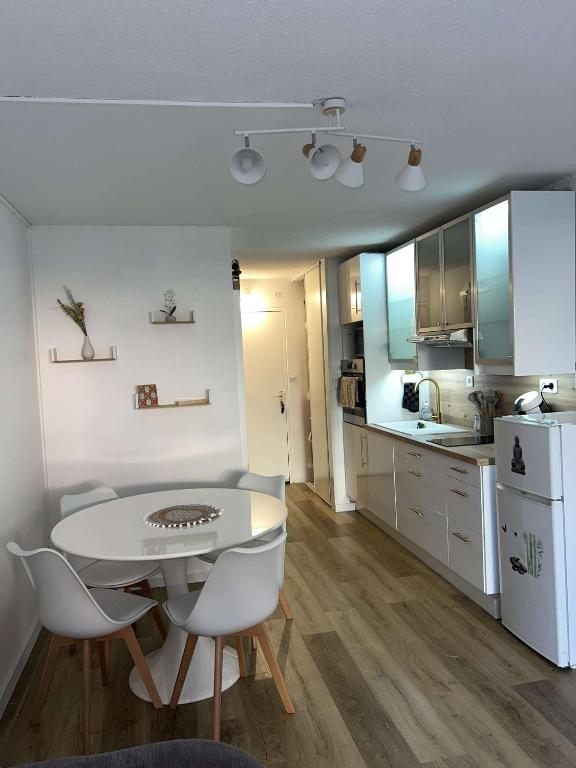 une cuisine et une salle à manger avec une table et des chaises dans l'établissement Mylilou location, au Cap d'Agde