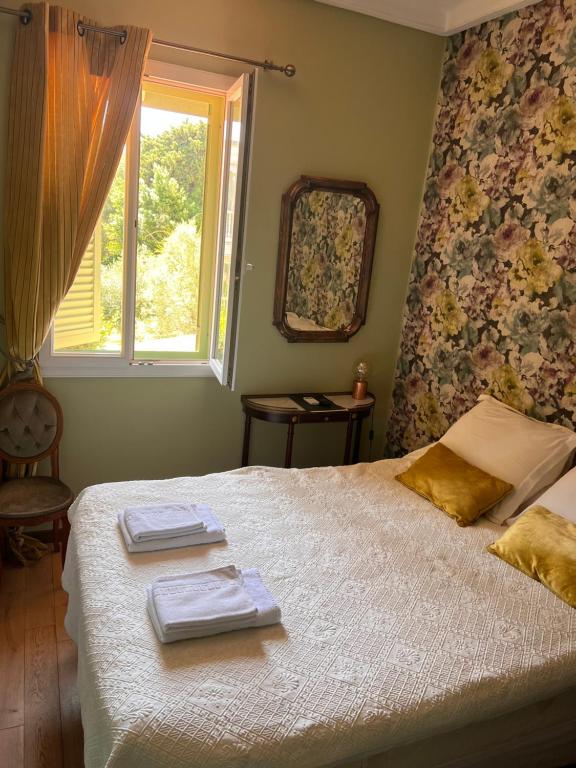 a bedroom with a bed with towels and a window at Hotel Le Ponteil in Antibes