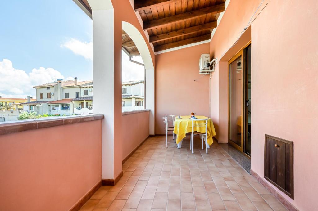 a balcony with a table with a yellow table cloth at Sweet Home in Portoscuso! in Piscinas