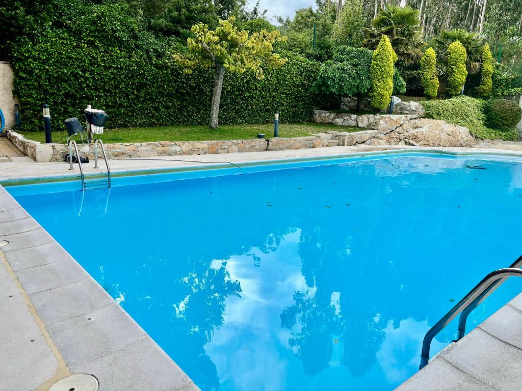 a large pool with blue water in a yard at Portosin Sea&Pool in Portosin