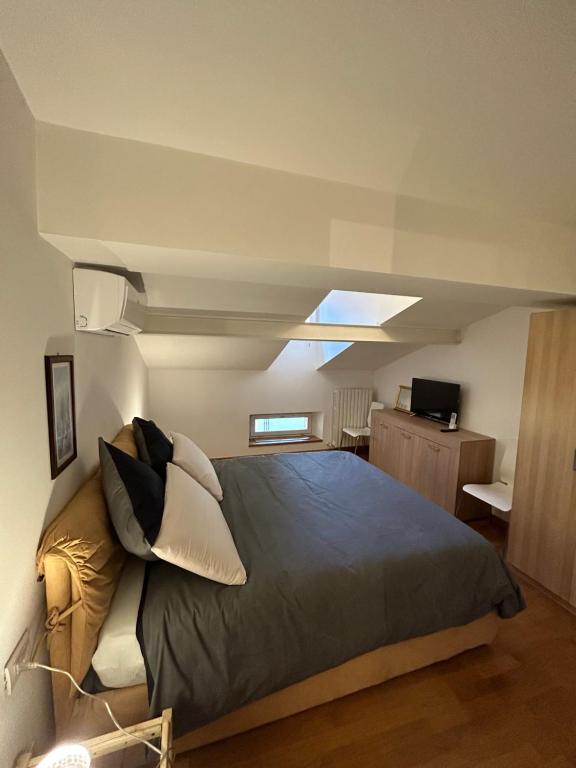 una camera con un grande letto e un lucernario di Appartamento centrale Housitaly a Lecco