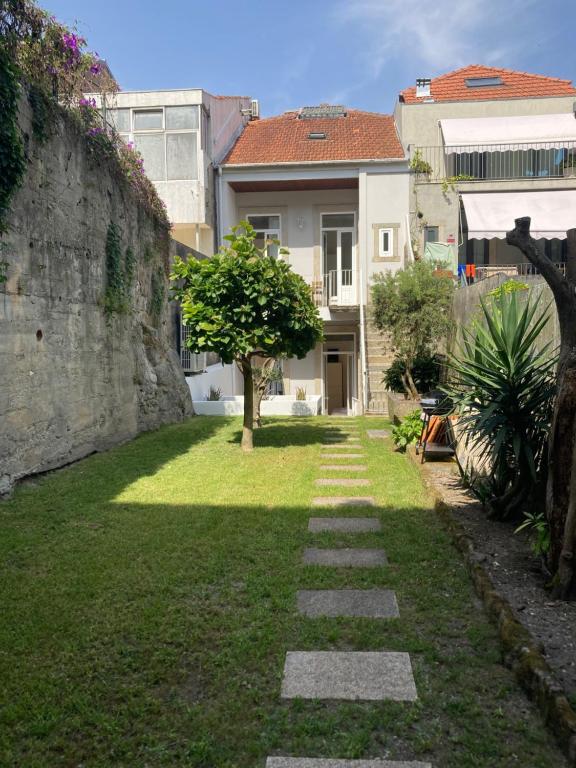Un jardín con un camino de piedra frente a un edificio. en Pombeiro Apartments, en Oporto