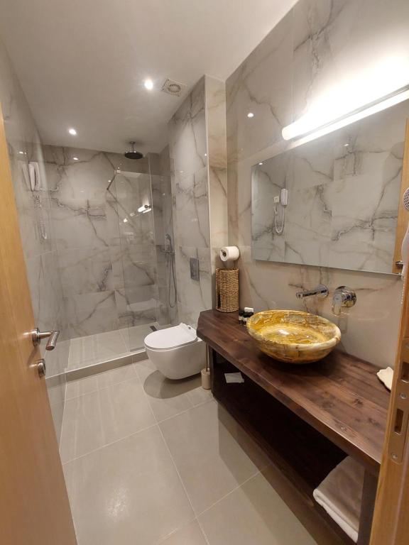 a bathroom with a sink and a toilet and a shower at Blue Bay Hotel in Iraklitsa