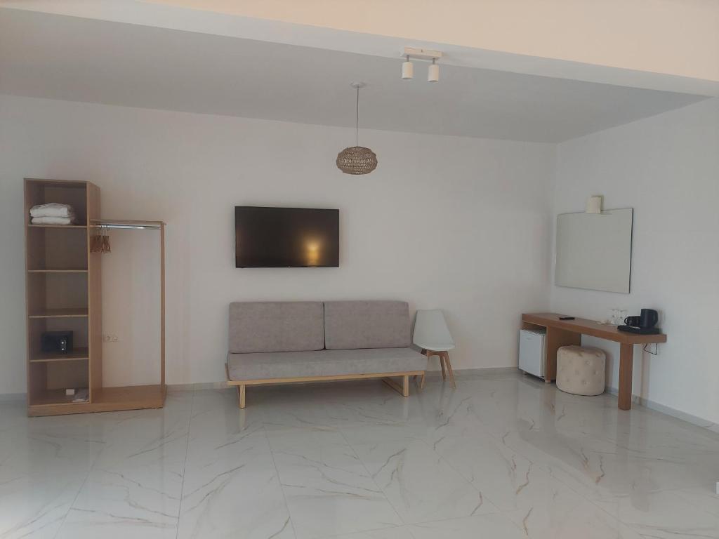 a living room with a couch and a tv at Blue Bay Hotel in Iraklitsa