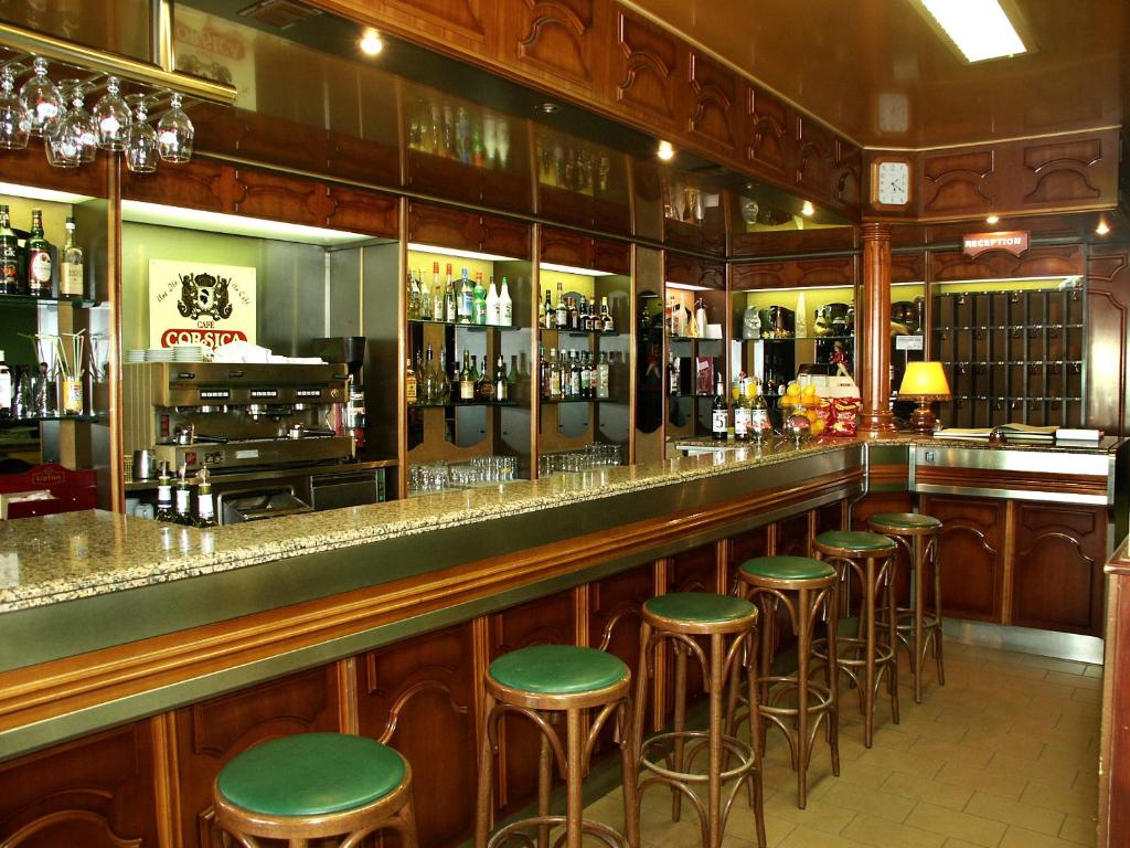 a bar with green stools in a restaurant at Hotel le Dauphin in Ajaccio