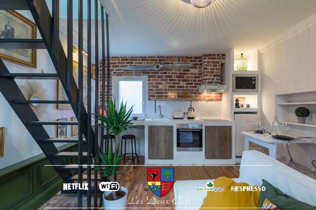 a kitchen with a staircase leading to a living room at Les deux clefs acte 2 in Mont-de-Marsan