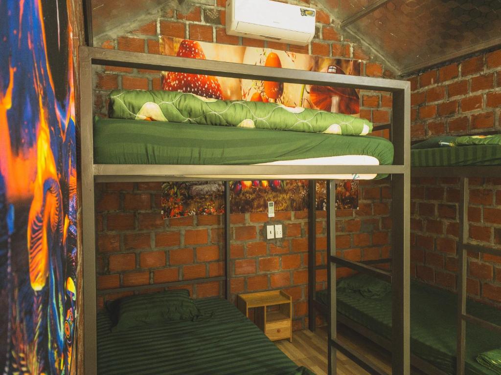 een kamer met 2 stapelbedden in een bakstenen muur bij Og homes in Ha Giang
