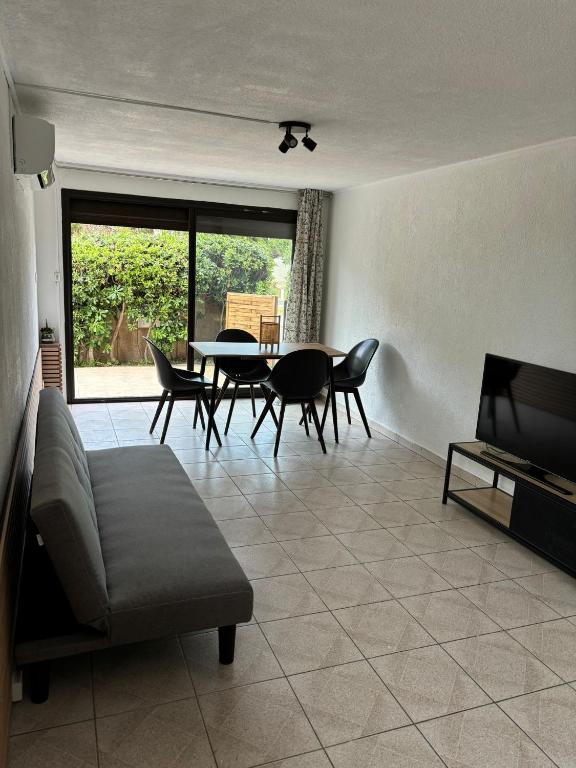 un salon avec un canapé, une table et des chaises dans l'établissement Appartement proche de la mer, à Sainte-Marie-la-Mer