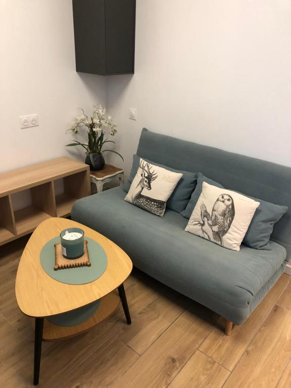 un soggiorno con un divano blu e un tavolo di Chez Julien à 2 pas de La Défense a Puteaux