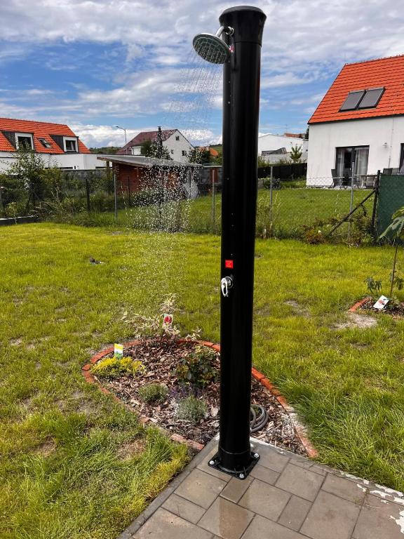 a black pole with a sprinkler in a yard at Apartmány Mikulovské zahrady in Mikulov