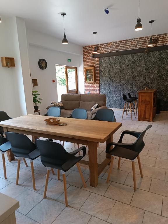 un salon avec une table et des chaises en bois dans l'établissement domaine des étangs du bois de l'abbaye, à Rejet-de-Beaulieu