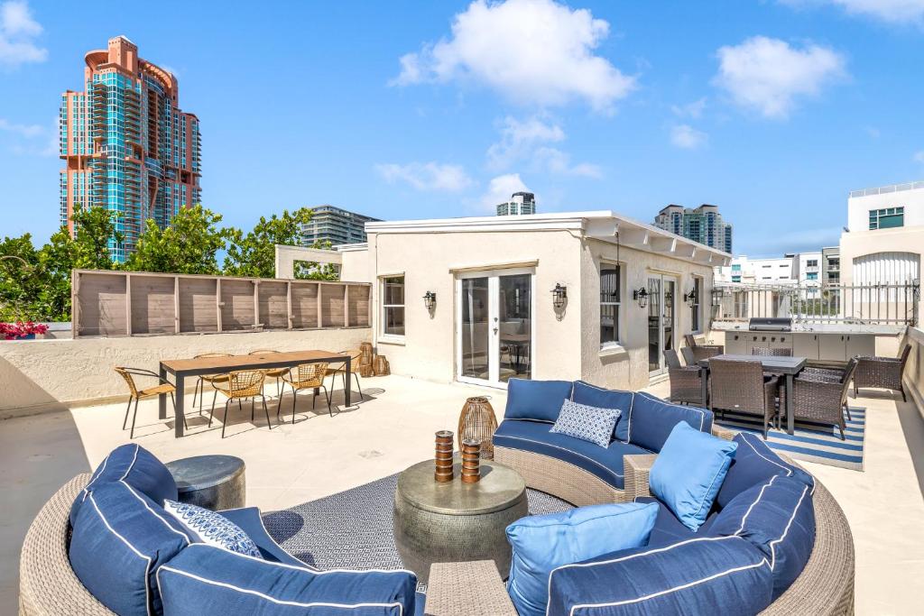 an outdoor patio with blue couches and a table at Gorgeous coastal PH with Large Private Terrace in Miami Beach