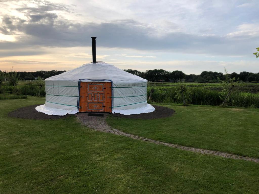 a yurt with a door in the middle of a field at Iloons yurt in Hollandscheveld