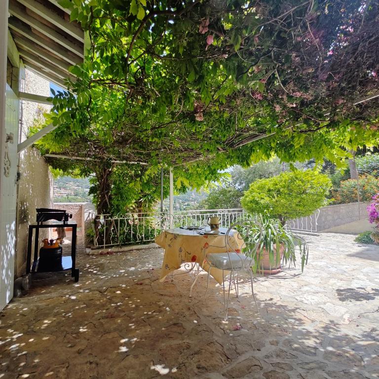 un patio avec une table, des chaises et une cheminée dans l'établissement Charmant T2 à cassis, à Cassis