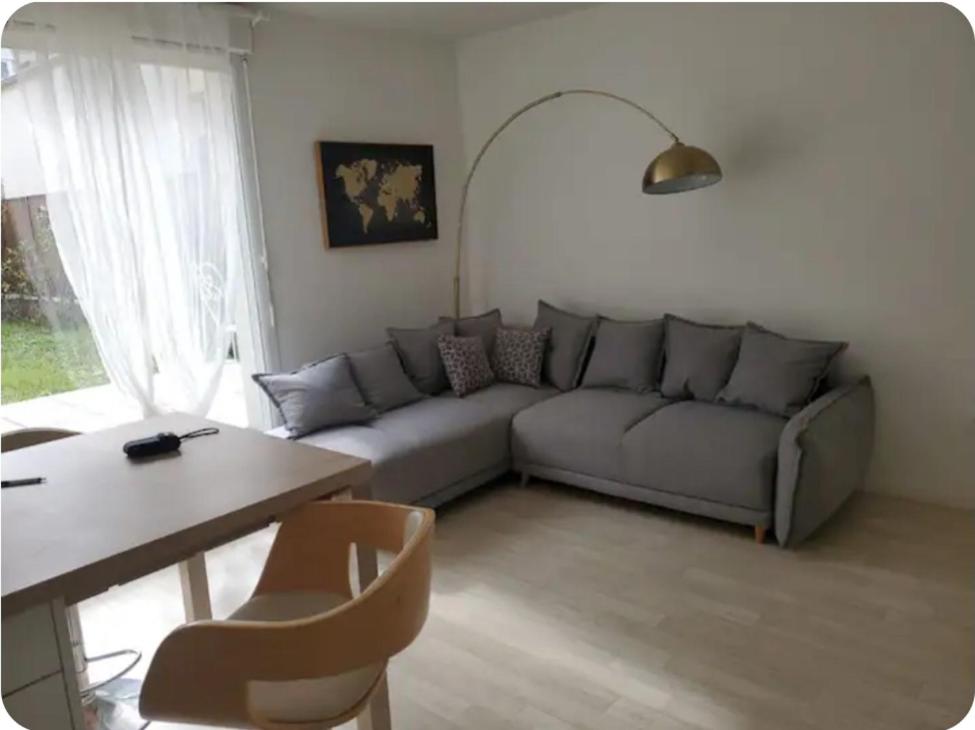 un salon avec un canapé et une table dans l'établissement Maison avec jardin et 2 places de parking, à Orly