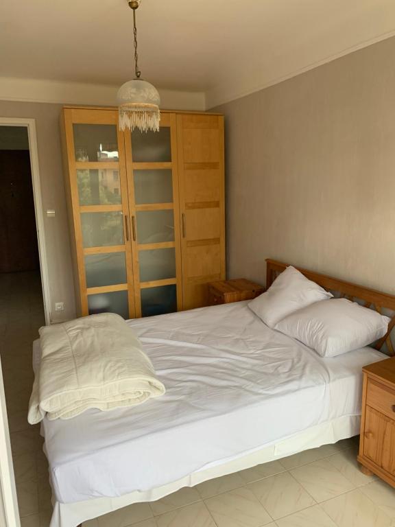 - une chambre avec un lit blanc et un lustre dans l'établissement Appartement FRÉJUS 300m de la PLAGE 3 Chambres 7 lits, à Fréjus
