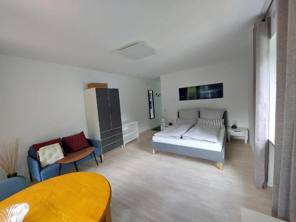 a bedroom with a bed and a chair and a table at Claar Ferienwohnung Lindau Bodensee in Lindau