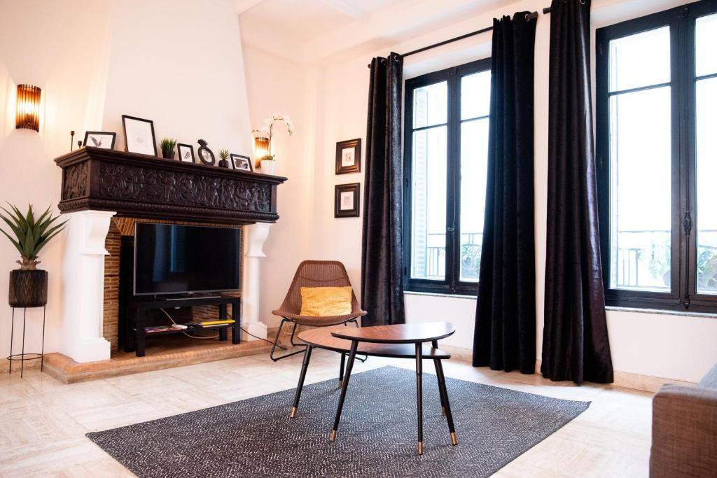 un salon avec une cheminée et une table dans l'établissement 101 Cour de la Bastide, à Carcassonne