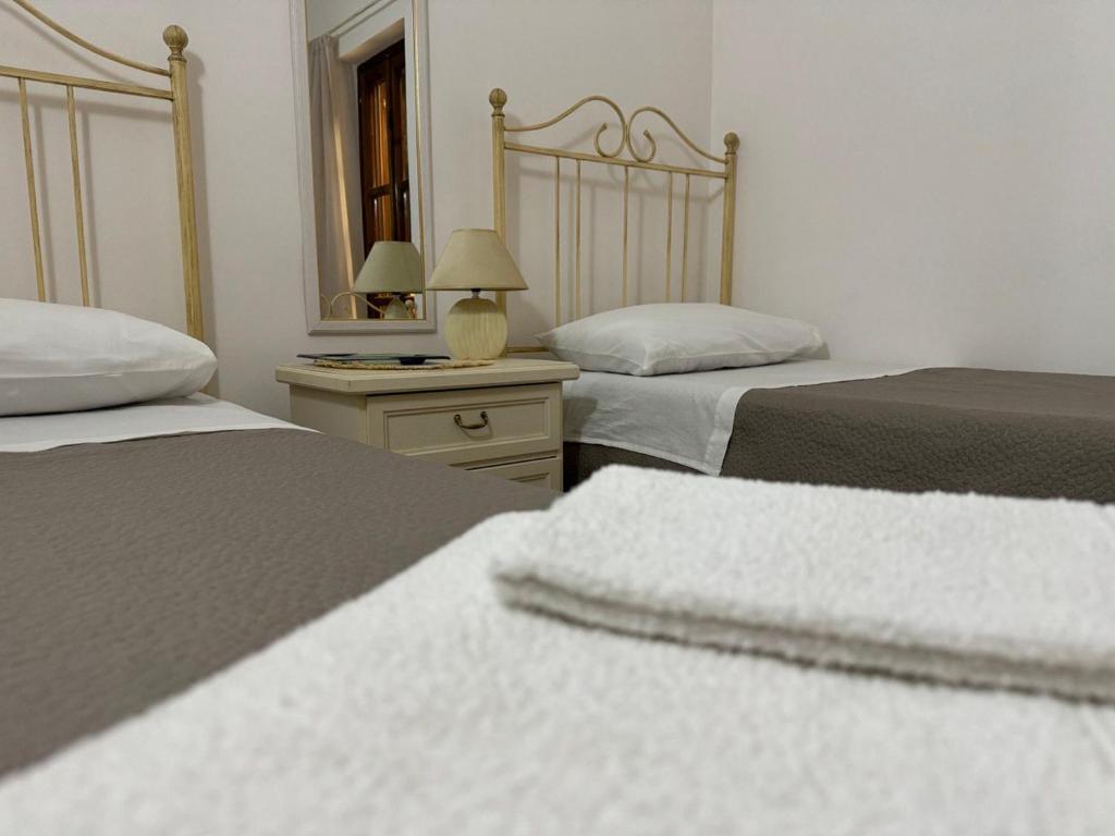 a bedroom with two beds and a mirror at Endless Summer House in I Casoni