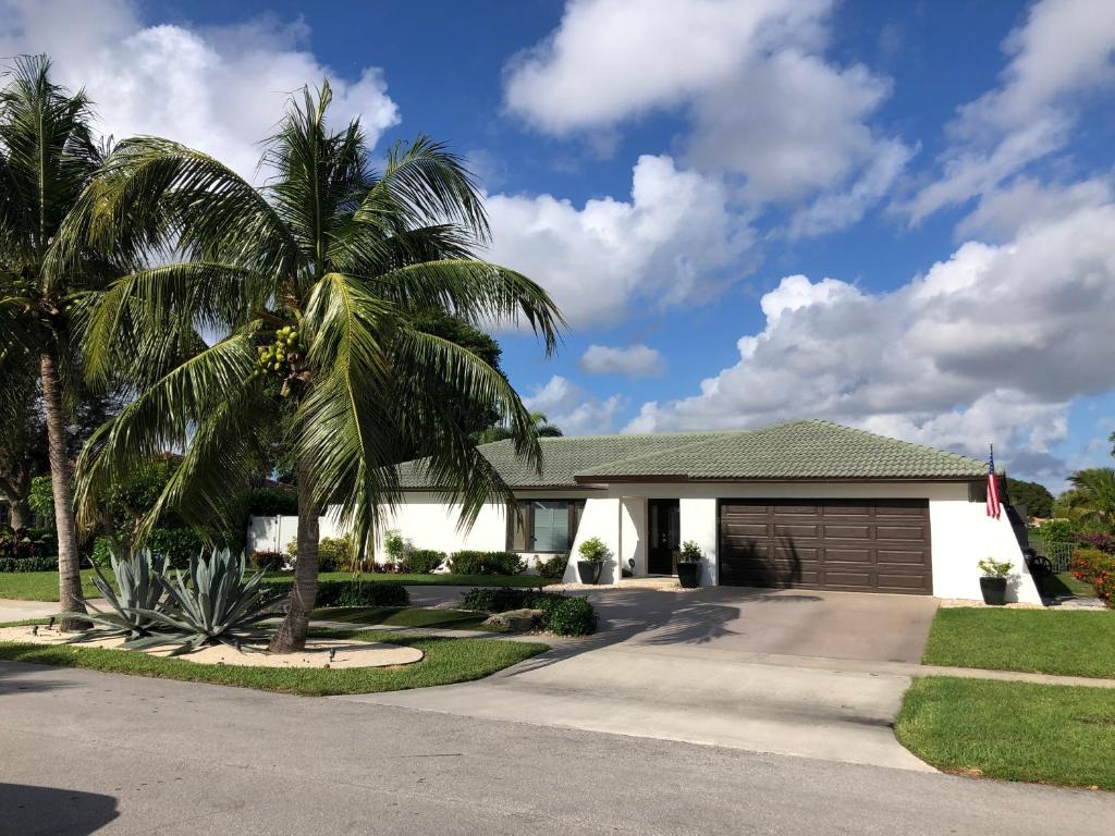 a palm tree in front of a house at Bright and Cheerful 4 bedroom Home with pool in Boca Raton