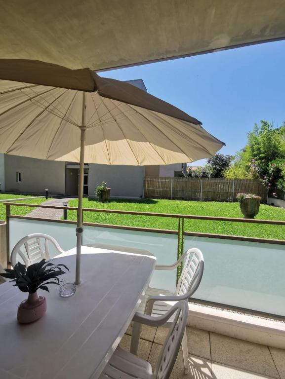 une table et des chaises avec un parasol sur un balcon dans l'établissement Appartement avec terrasse, à Montpellier