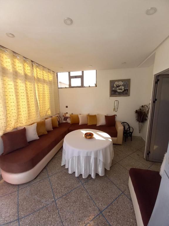 a living room with a large couch and a table at Marjane house in El Jadida