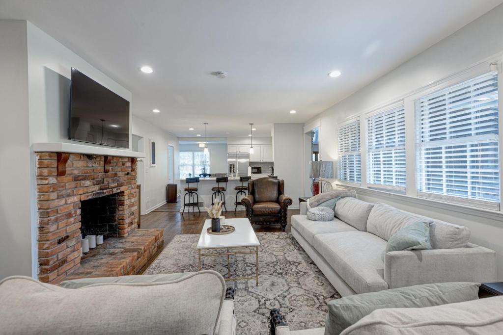 コロンバスにあるGroup Getaway 6BR Near Fort Benning Huge Kitchen Private Yardのソファと暖炉のあるリビングルーム