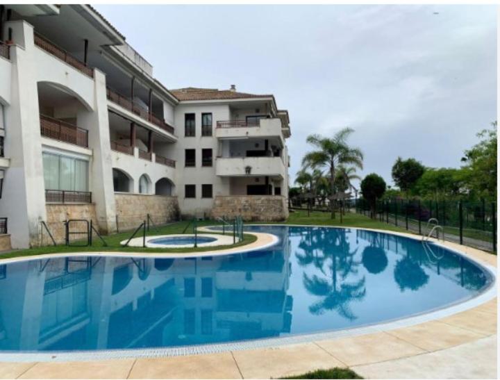 ein großes Schwimmbad vor einem Gebäude in der Unterkunft Apartamento con vistas para 5 personas in El Rompido