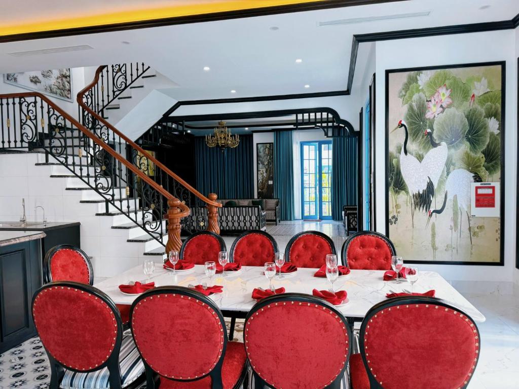 une salle à manger avec une table et des chaises rouges dans l'établissement Biệt Thự Gần Biển Bãi Cháy Và Bãi Marina, à Hạ Long