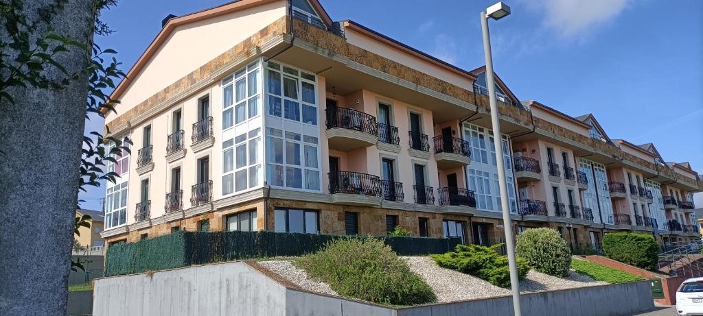 ein Mehrfamilienhaus mit Balkonen an einer Straße in der Unterkunft Oasis o,xuncal in San Cosme de Barreiros